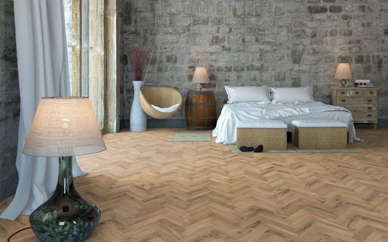 Bedroom with plain concrete walls and W-patterned light brown floors